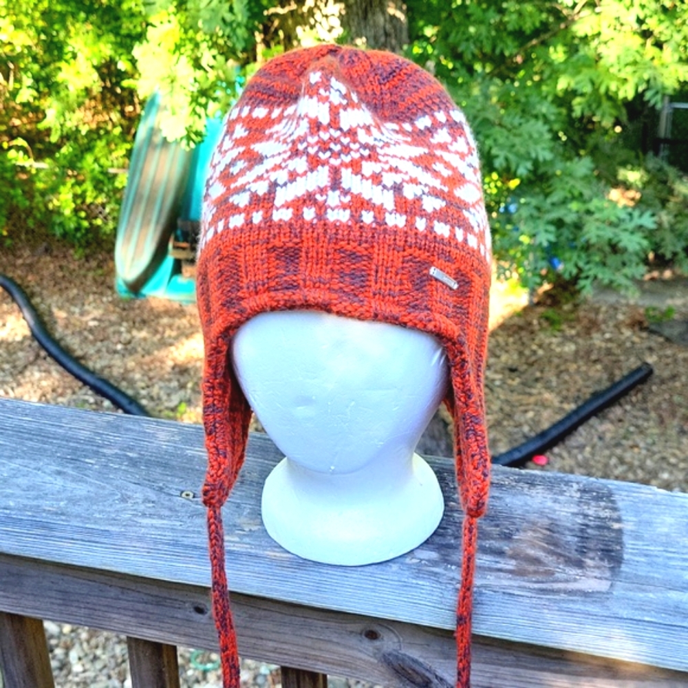 Winter knit cap with ear flaps and ties, burnt orange with white snowflake